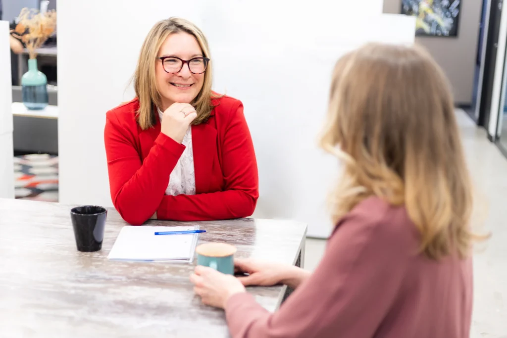A member of the Client Services Team talking warmly with a client across a desk